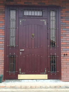 парадная дверь со стеклянными фрамугами и решетками