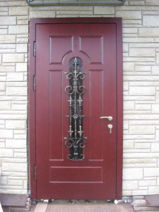 красная дверь с ковкой в каменном доме