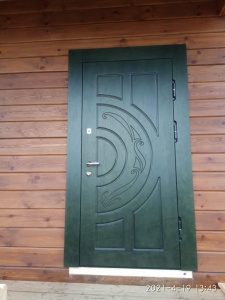 Зеленая дверь в деревянном коттедже